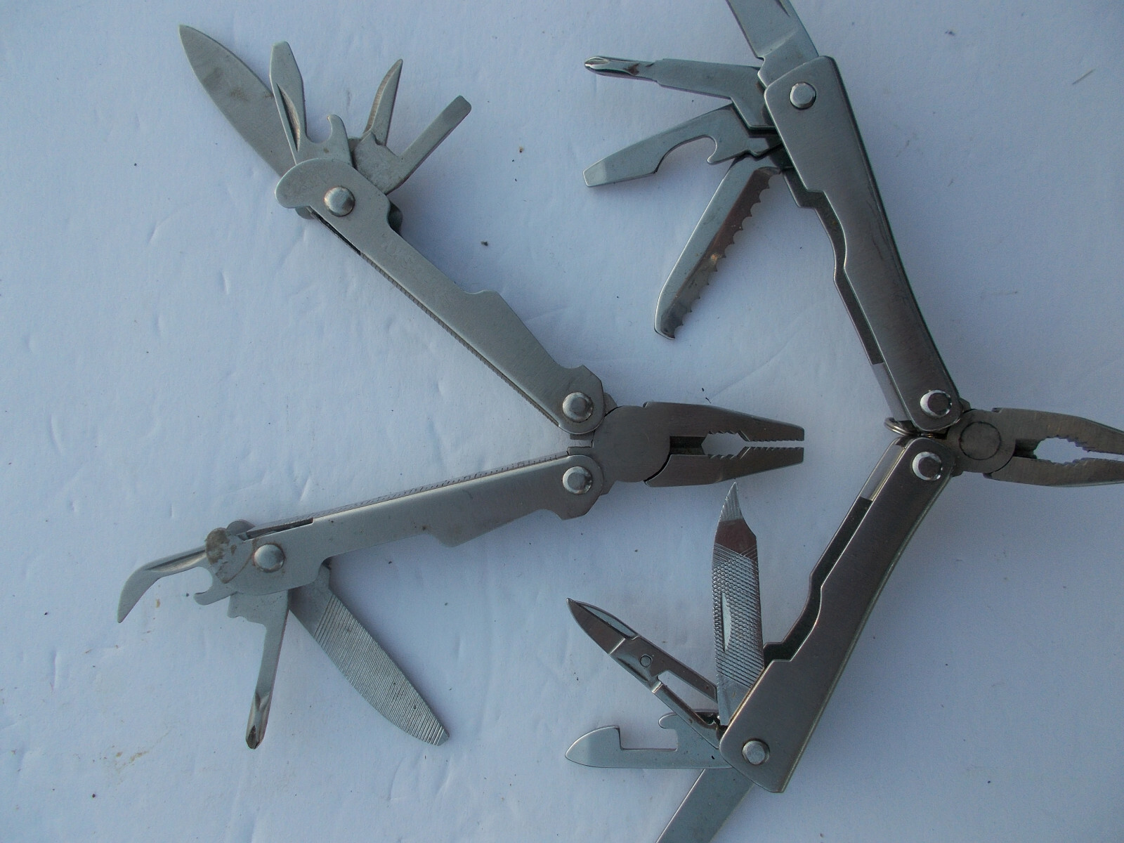 Lot of (2) multi tools – 1 Husky silver color and 1 unbranded silver color